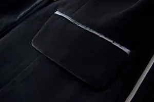 Detailed macro view showing the pocket and fabric texture of a black velvet blazer