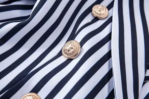 Vista detallada de un blazer a rayas con botones dorados decorados con cabeza de león.
