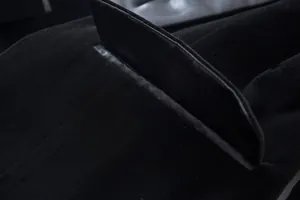 Macro close-up showing the pocket flap detail and soft velvet fabric of a black blazer
