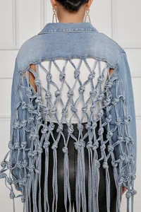 Vue détaillée du dos en résille nouée et des franges d'une veste en jean bleu clair