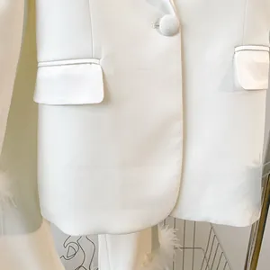 Close-up of elegant snow white blazer with single button and irregular hem details