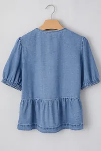 Vista posteriore di un top casual in denim blu con orlo a peplo e maniche a sbuffo
