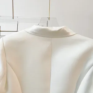 Detailed view of a minimalist snow white blazer lapel with a high-quality satin-like finish