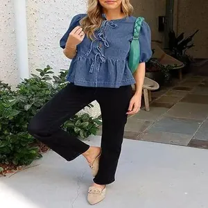 Vista a figura intera di una donna che indossa una camicia di jeans blu con maniche a sbuffo