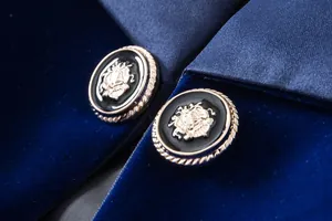 Close-up detail of luxury navy velvet blazer with golden embossed crest buttons
