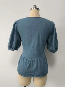 Vista posteriore di una camicia peplo in denim blu con maniche a sbuffo su manichino