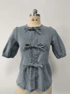 Vista dettagliata di camicia in denim blu chiaro con tre fiocchi decorativi per le donne