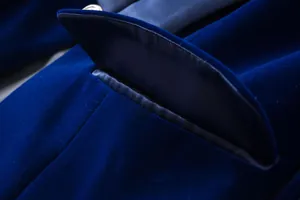 Macro detail shot of royal blue velvet blazer pocket flap showing premium fabric texture