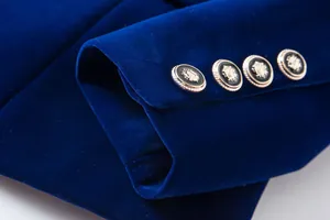 Luxury blue velvet blazer sleeve detail featuring decorative gold crest buttons