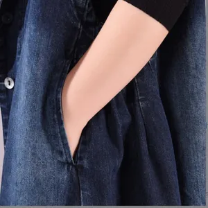 Detailed view of the side pocket on a dark blue denim sleeveless long dress vest