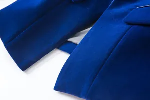 Macro detail view of luxurious royal blue velvet blazer sleeve and pocket seam.