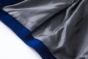 Close-up detail showing royal blue velvet texture and smooth grey inner lining of blazer