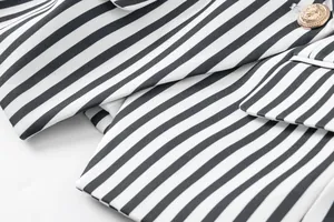 Vista macro de tela de chaqueta a rayas blancas y negras y botón dorado de cabeza de león