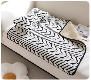 Gros plan d'un tapis en peluche pour animaux avec motif chevron noir et blanc sur sofa