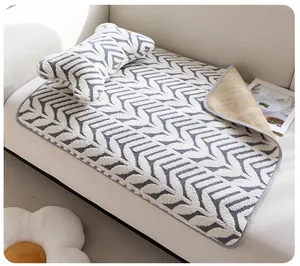 Détail du tapis en peluche pour animaux avec motif chevron gris et envers antidérapant