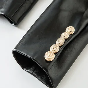 Detalle de manga de chaqueta de cuero sintético negro con cinco botones dorados de león.