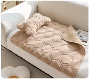 Détail du tapis en peluche pour animaux avec motif hexagonal et coussin os