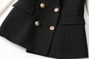 Detailed view of black double-breasted blazer featuring intricate gold lion-head buttons.
