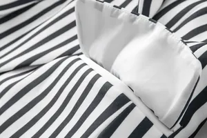 Vista macro de las costuras y el detalle del bolsillo de una chaqueta de rayas blancas y negras