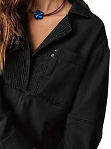Détail d'une veste en jean noire avec un design de poitrine plissé et un col en V