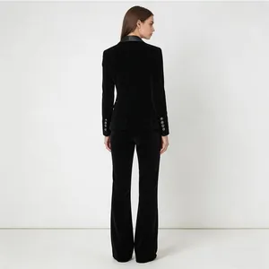 Back view of a luxury black velvet suit featuring a shawl collar blazer and flared pants