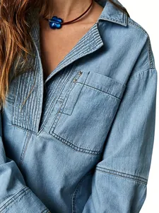 Détail de la veste en jean bleu clair avec col en V et design plissé élégant devant