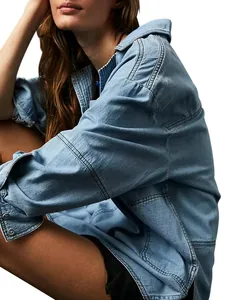 Détail d'une veste en jean bleu clair montrant les coutures et la texture de qualité.