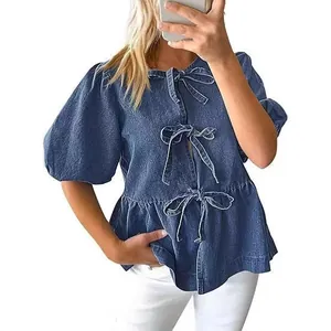 Elegante camicetta in denim blu da donna con maniche a sbuffo e chiusure a fiocco sul davanti.