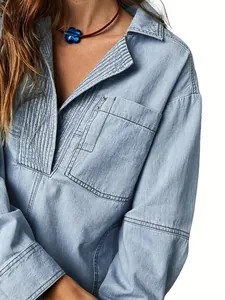 Gros plan sur une veste en jean bleu clair avec détails plissés et col en V