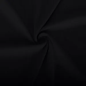 Macro view of black ribbed knitted fabric texture featuring an elegant swirl arrangement