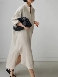 Detalle de un vestido camisero de algodón y lino oversize con aberturas laterales y botones