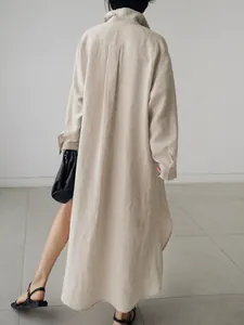 Vista trasera de un vestido camisero de algodón y lino beige oversize con dobladillo largo
