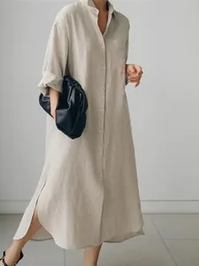 Detalle de un vestido camisero largo de algodón y lino beige con aberturas