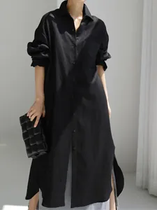 Vista detallada de un vestido camisero oversize de algodón y lino negro con aberturas laterales