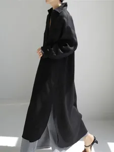 Vista lateral de vestido camisero largo de lino negro con abertura alta y ajuste holgado
