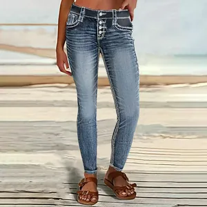 Detail shot of high-waisted blue skinny jeans with multi-button fly and contrast stitching.