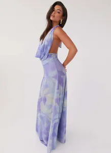 Side view of elegant purple floral halter backless maxi dress in light studio setting