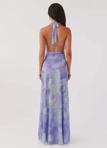 Back view of an elegant purple floral printed halter maxi dress with backless design