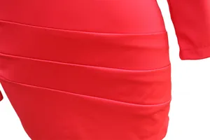 Dettaglio macro della trama plissettata a strati su un abito rosso aderente da donna