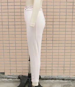 Side view detail of high waist elastic PU leather leggings in a light beige finish