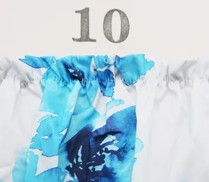 Détail de l'encolure élastique froncée avec imprimé floral bleu sur tissu blanc