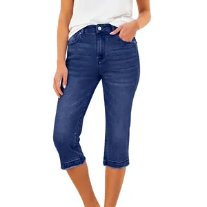 Détail d'un pantalon capri en denim extensible bleu foncé pour femme à l'ourlet effiloché