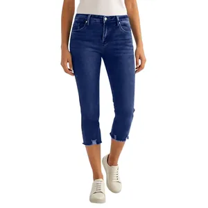 Gros plan sur un pantalon court en denim stretch bleu avec des ourlets effilochés