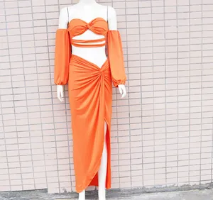 Nahaufnahme des sexy orangefarbenen Zweiteilers mit Twist-Top und Maxirock mit Schlitz
