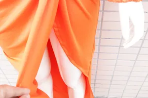 Detailansicht des sexy Seitenschlitzes und des elastischen orangefarbenen Stoffes