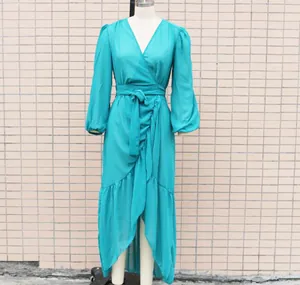 Detailed view of a teal chiffon wrap dress featuring a ruffled hem and long puff sleeves.