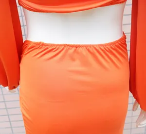 Detailaufnahme der elastischen Taille und des Cut-out-Designs bei einem orangen Bodycon-Kleid