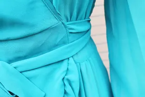 Close-up of waist tie and pleated chiffon fabric of turquoise beach dress cover-up