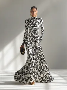Elegante vestido largo con estampado floral en blanco y negro y detalles fruncidos.