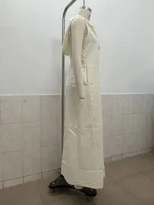Side profile of a white sleeveless hooded maxi dress featuring front buttons on mannequin.